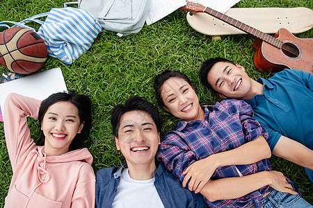 快乐的青年大学生躺在草地上高清图片