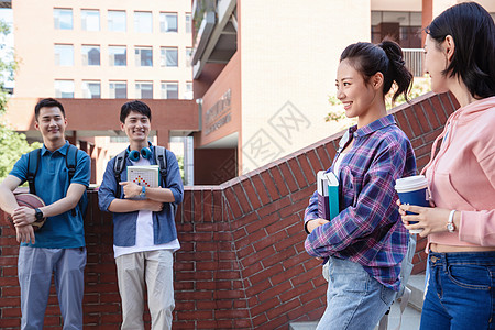 四个人刚下课的大学生在校园里高清图片