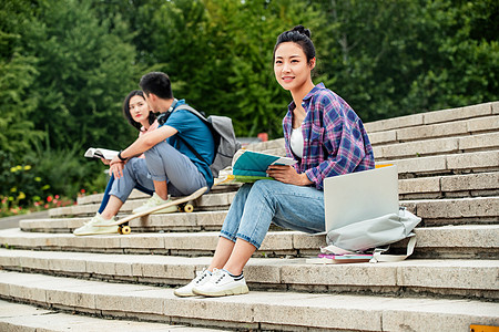 快乐的大学生坐在台阶上学习高清图片