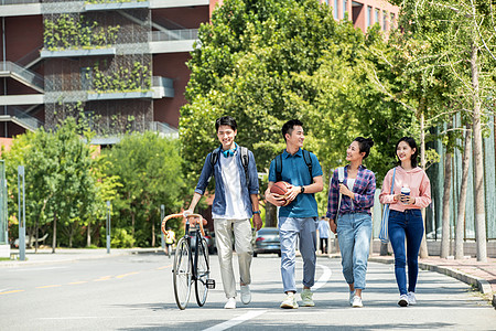 在校大学生阳光下快乐的大学生在校园里步行背景