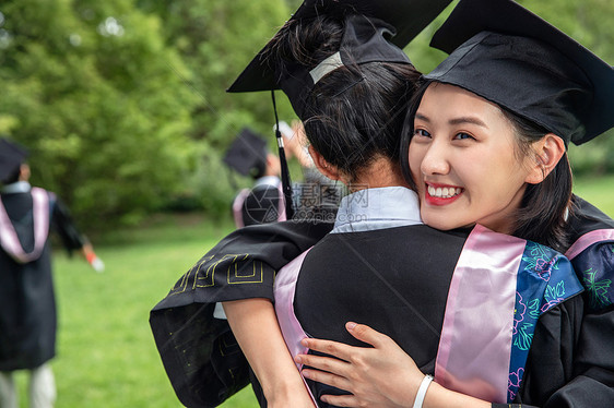 人生大事户外穿着学士服的大学生拥抱告别图片