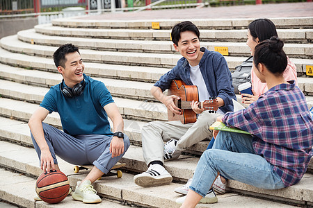 同学课外活动彩色图片年轻的大学生坐在台阶上闲聊图片