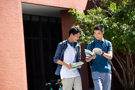 幸福成年学生高兴的校园里边走路边探讨学习的年轻男子图片