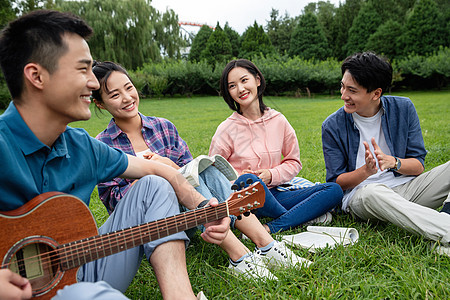 笑高等教育课外活动快乐的大学生在草地上弹吉他唱歌图片