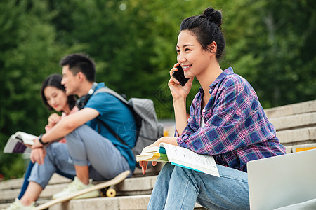 快乐的大学生坐在台阶上打电话高清图片