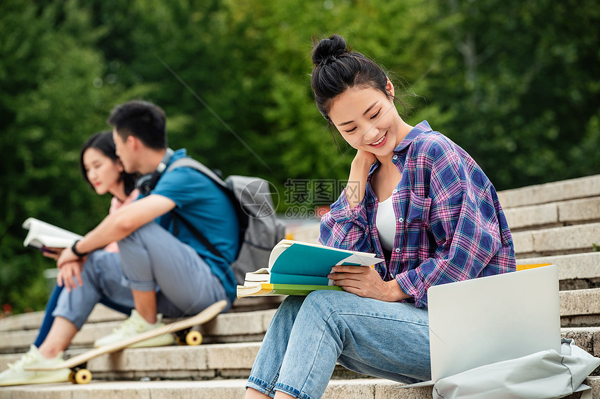 快乐的大学生坐在台阶上学习图片