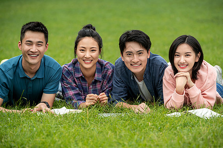白昼乐趣排列快乐的大学生趴在草地上图片