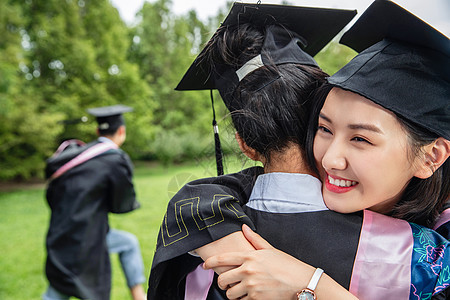 户外穿着学士服的大学生拥抱庆祝图片