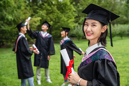 新同学户外穿着学士服的大学生们背景