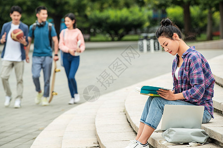 校园里坐在台阶上自学的大学生高清图片