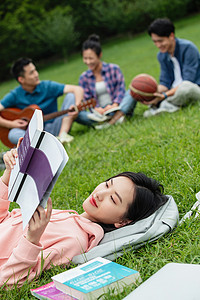 青年女大学生在草地上享受课余时间图片