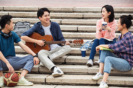 彩色图片社交书包年轻的大学生坐在台阶上闲聊图片