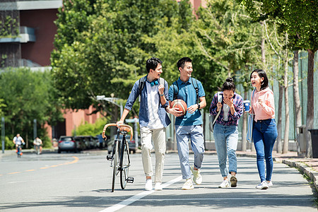 活力女性快乐的大学生在校园里步行背景