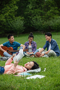 四个人欢乐弹奏大学生在草地上享受课余时间图片