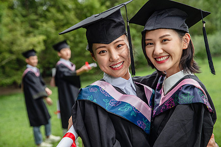 新同学穿着学士服的女大学生们背景