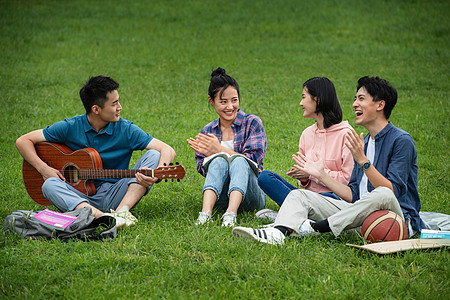 户外青年女人彩色图片快乐的大学生在草地上弹吉他唱歌图片