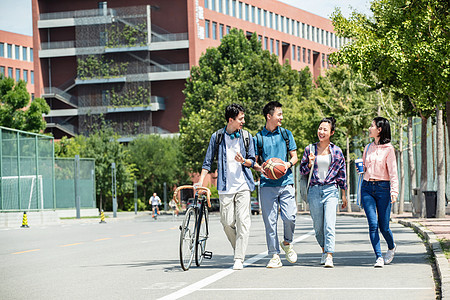 四个人相伴快乐的大学生在校园里步行图片