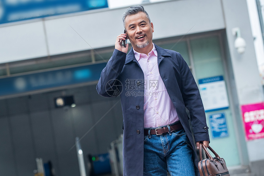 拎着公文包打电话的商务中老年男子图片