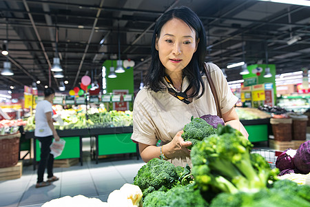 中年女在超市挑选蔬菜图片