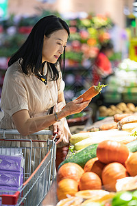 中年女在超市挑选蔬菜图片