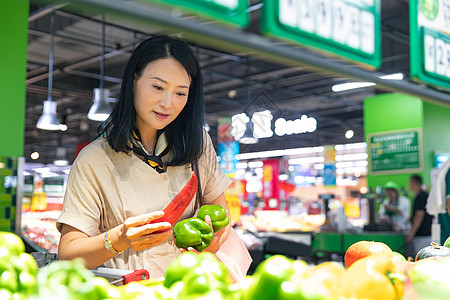 蔬菜北京中年女在超市挑选蔬菜背景