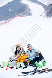 孩子嬉戏一家人自家到雪场滑雪背景