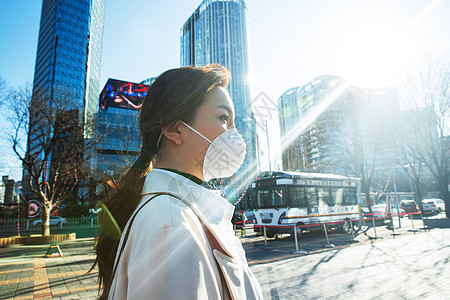 青年女人戴口罩在户外行走图片