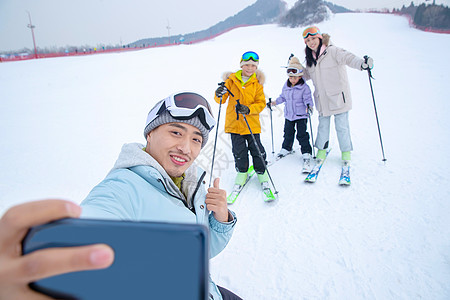 雪地玩耍带儿子女儿冬日滑雪的父母背景