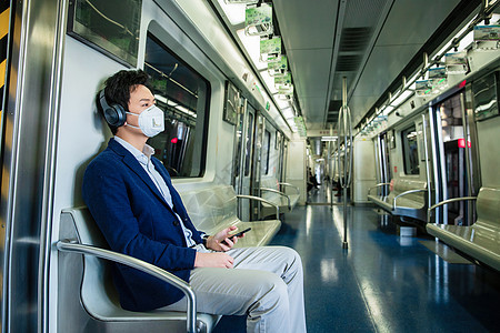 车厢青年男子戴口罩乘坐地铁图片