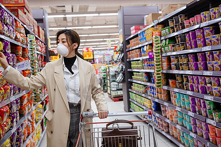 戴口罩的青年女人在超市购物图片