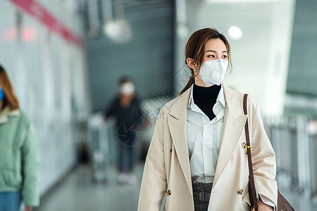 雾霾背景戴口罩的年轻女人走在地铁站里背景