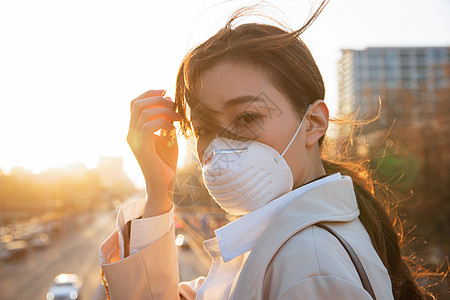 预防新型冠状传染病防疫户外戴口罩的青年女人图片