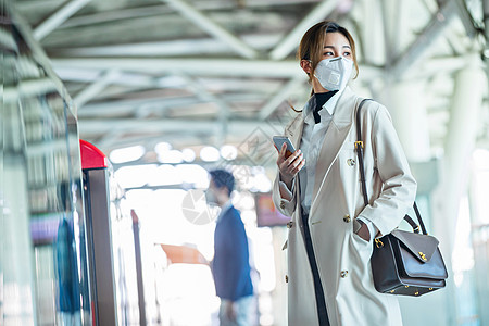 疫情安全戴口罩的年轻女人站在地铁站台上图片