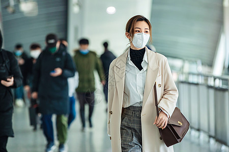 雾霾背景通勤者地铁月台戴口罩的年轻女人走在地铁站里背景