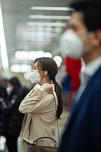 戴口罩的年轻女人站在地铁站台上高清图片