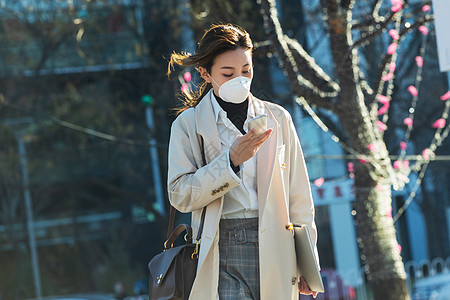 室内雾霾上下班通勤者戴口罩的青年女人看手机背景