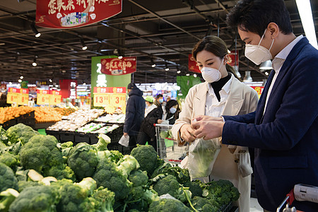 青年夫妇戴口罩在超市购买青菜图片