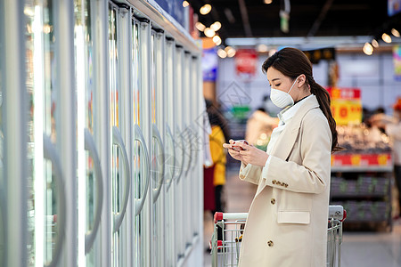 超市橱窗传染病戴口罩的青年女人在超市购物背景