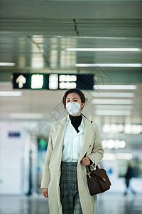 雾霾城市上班族戴口罩的年轻女人走在地铁站里背景