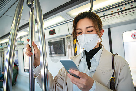 环境问题防流感口罩青年女人在地铁上看手机背景