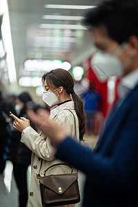 绿色出行戴口罩的青年人站在地铁站台上高清图片