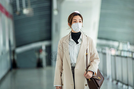 雾霾城市休闲装通勤者女商人戴口罩的年轻女人走在地铁站里背景