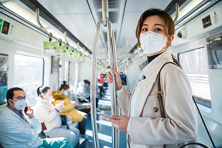 城市戴口罩的年轻女人乘坐地铁图片