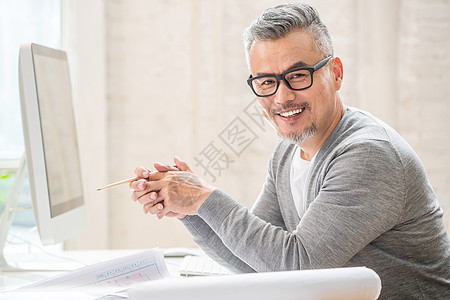 两手一摊在室内研究图纸的中老年设计师男士背景