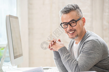 在室内研究图纸的中老年设计师男士高清图片