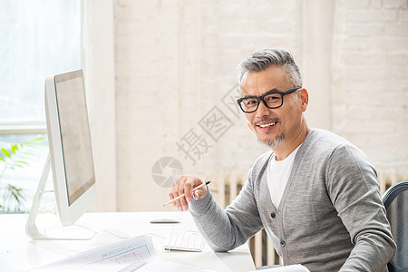 在室内研究图纸的中老年设计师男士图片