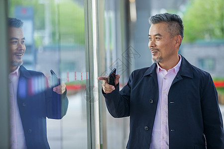 商务男士看橱窗反射的自己图片