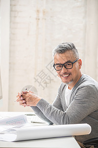 在室内研究图纸的中老年设计师男士图片