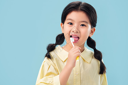 个人成长东方人享乐注视镜头拿着牙刷刷牙的小女孩背景