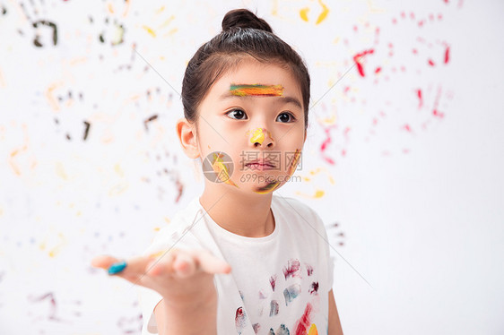 活力多色的漂亮的脸上涂满颜料的小女孩图片